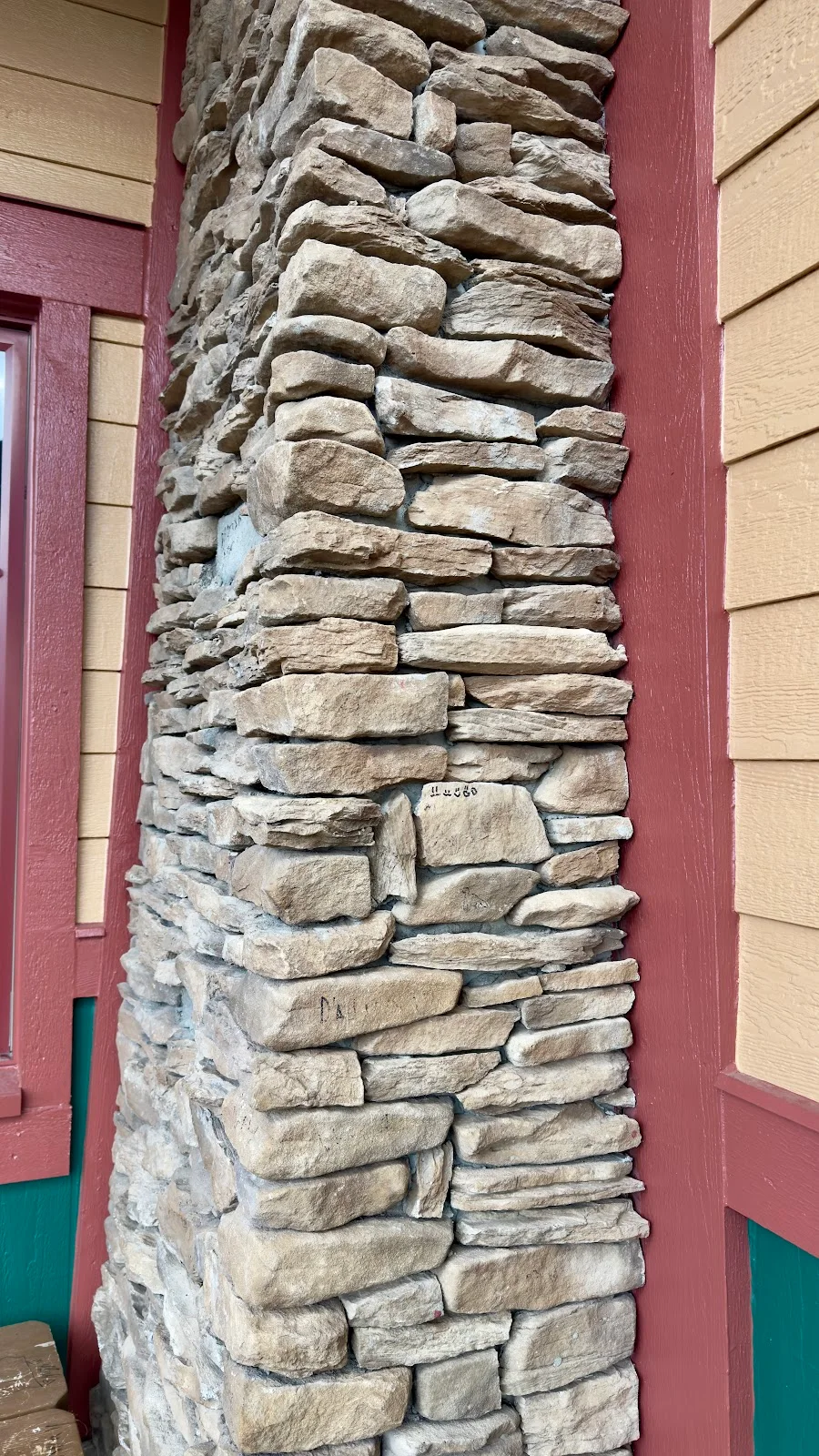 Clean cut line between natural stone pillar and burgundy trim